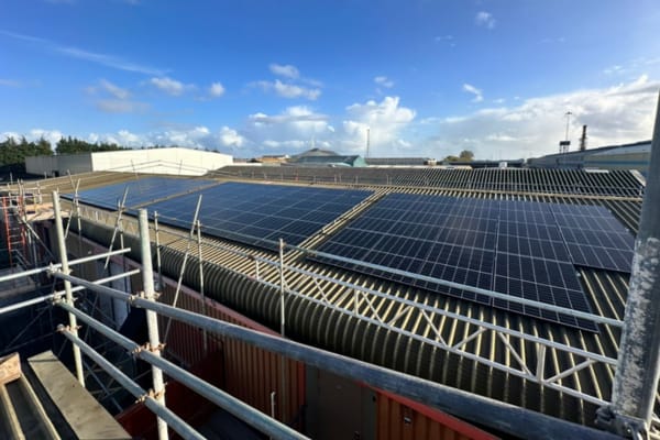 View across a commercial warehouse roof with solar panels installed by InspireGreen.