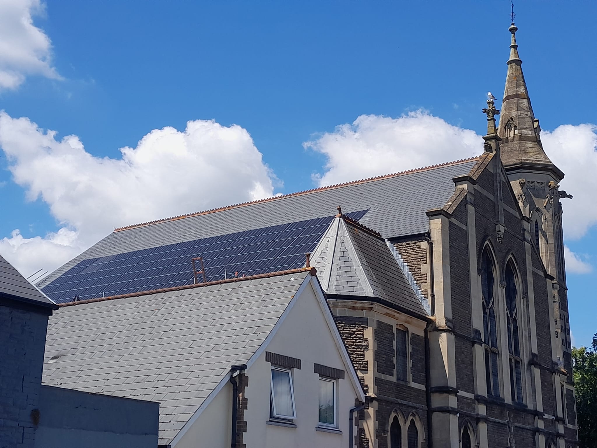 View from below of solar PV panels installed onto the side of the former church roof.
