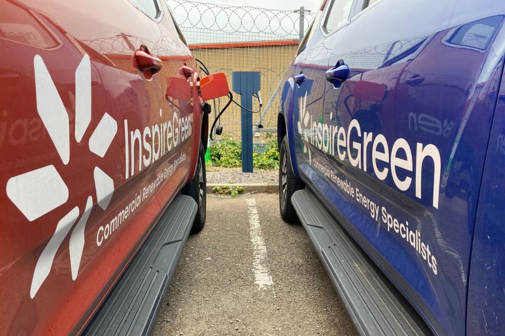 Two InspireGreen vehicles charging at an EV station.