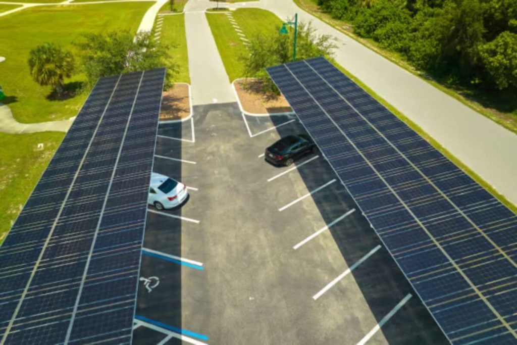 Solar panels sheltering cars in a car park.