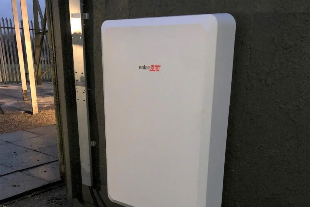 A rectangular grey SolarEdge battery mounted on a wall.